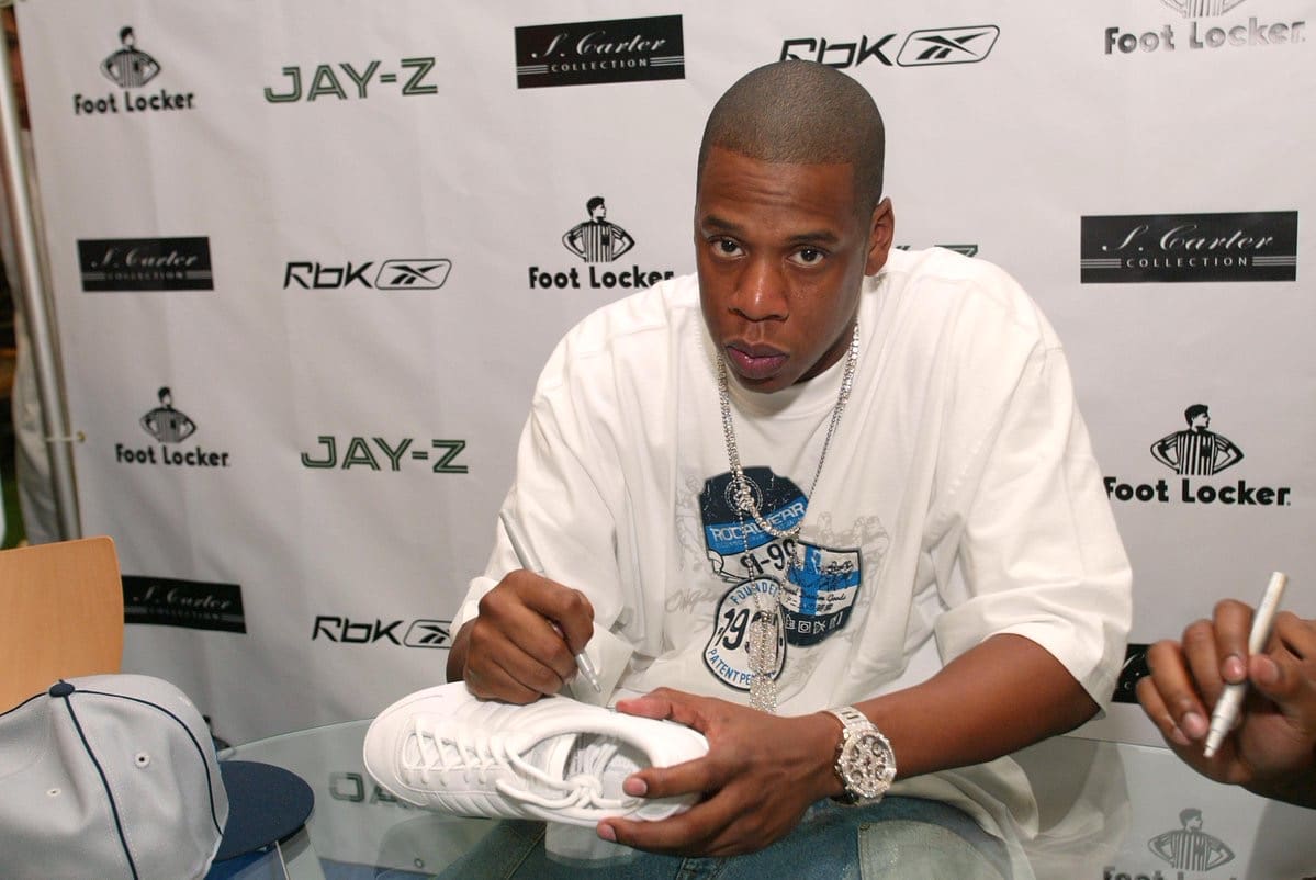 Jay-Z signing sneakers while wearing a Jacob & Co Five Time Zone