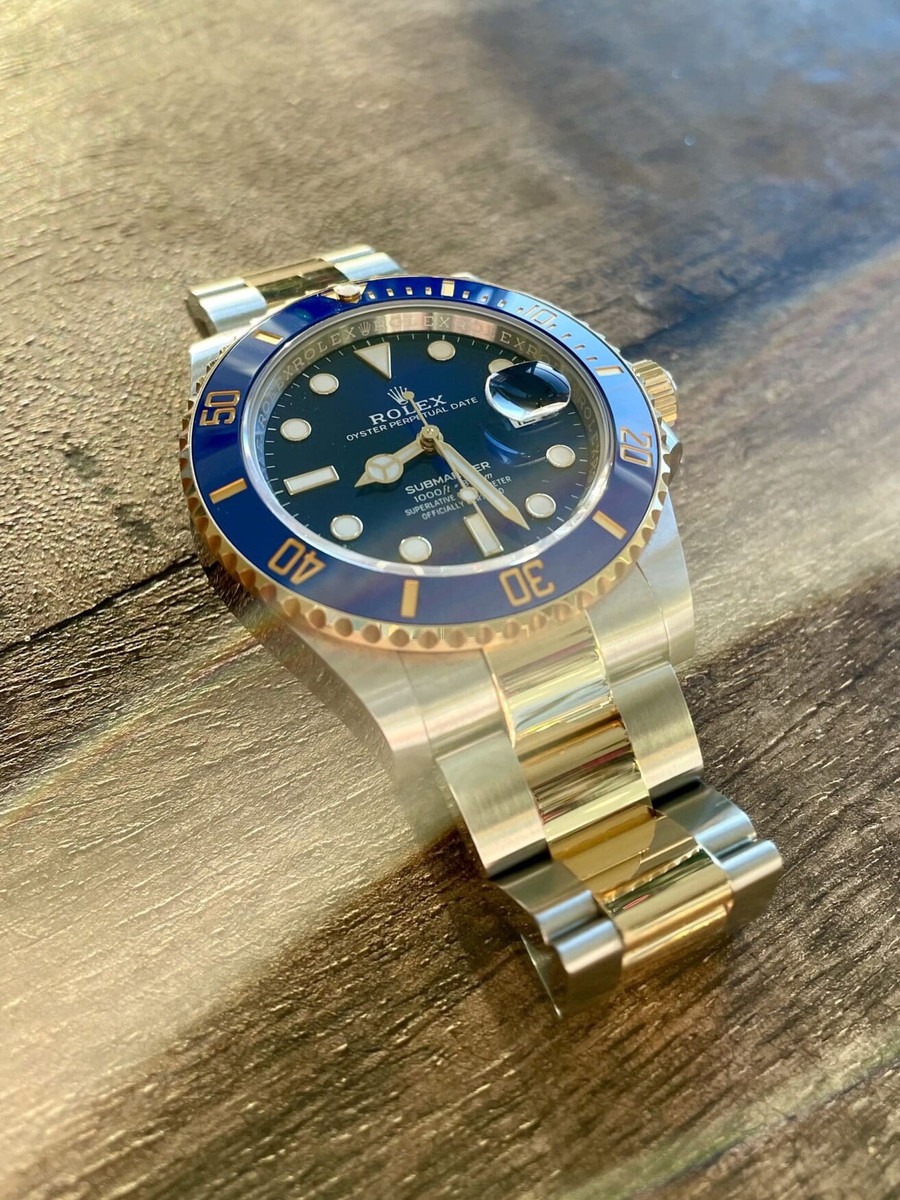 Rolex Submariner 126613LB on a wooden surface.