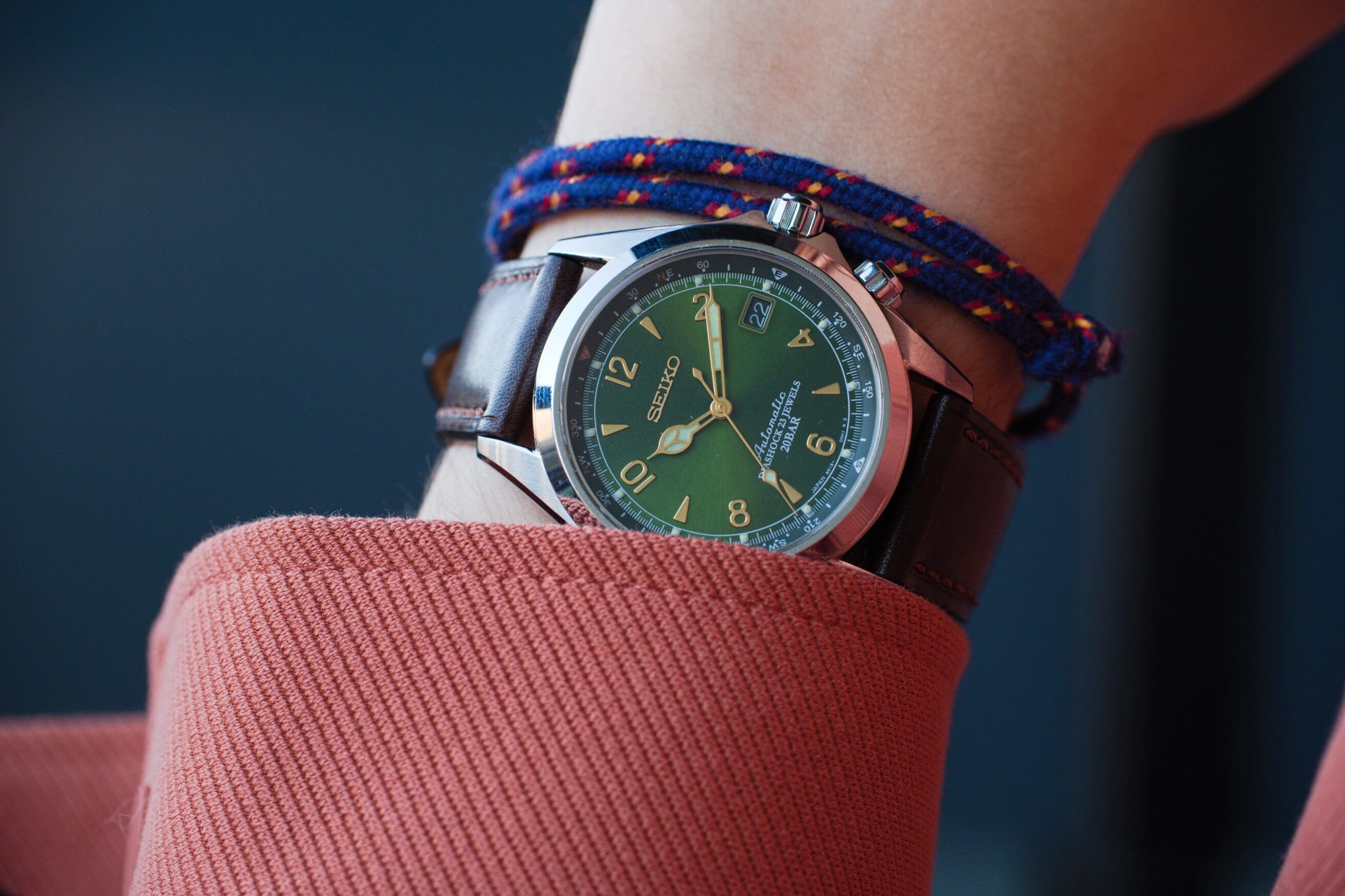 Zelos Spearfish 40mm dive watch with green dial on wrist with red sleeve.